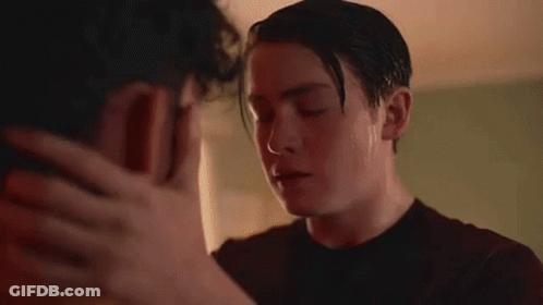 Two Men Kissing In Room With Flowers GIF