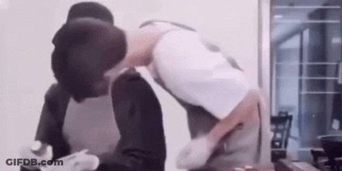Two Men Kissing While Cooking GIF