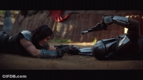 Two Men Laying On Ground Holding Guns GIF