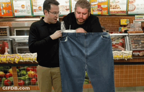 Two Men Looking At A Pair Of Jeans In A Subway Store GIF