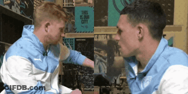 Two Men Looking At Each Other In Front Of This Is Our City Sign GIF