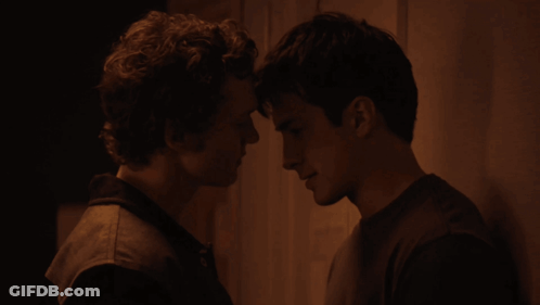 Two Men Looking At Each Other In The Dark GIF