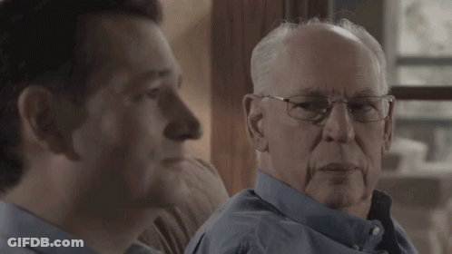 Two Men Looking At Each Other One With Glasses GIF