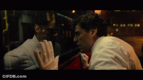 Two Men Looking At Each Other Through Window GIF