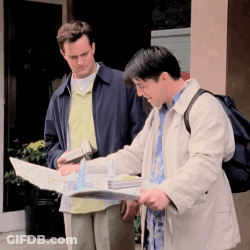 Two Men Looking At Map One With Backpack GIF