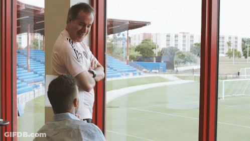 Two Men Looking Out Window At Field GIF