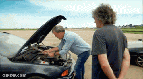Two Men Looking Under The Hood Of A Car With The Hood Open GIF