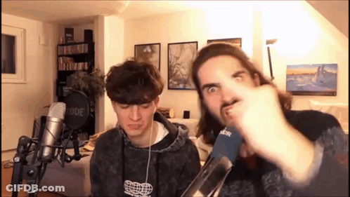 Two Men Making Funny Faces At Microphones GIF