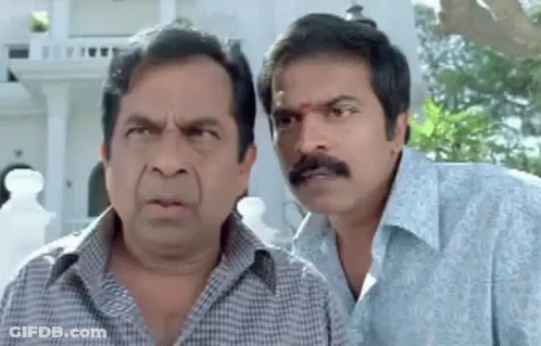 Two Men Making Funny Faces In Front Of Building GIF