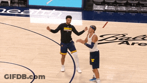Two Men On A Basketball Court One Wearing A Shirt That Says Denver Nuggets GIF