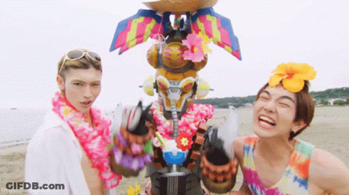 Two Men On Beach One Wearing Lei GIF