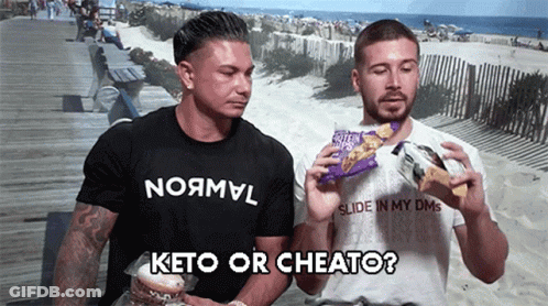 Two Men On Boardwalk One With Keto Or Cheato Shirt GIF