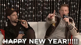 Two Men On Couch One Giving Middle Finger GIF