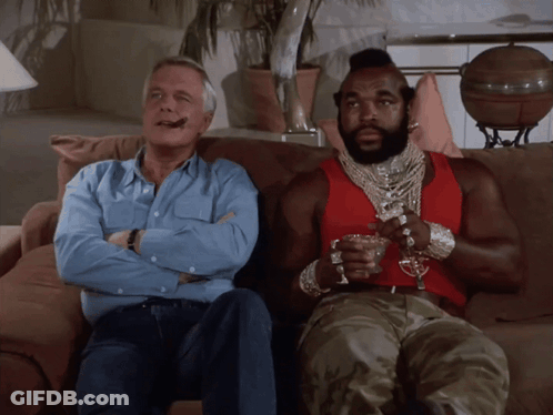 Two Men On Couch One In Red Tank Top GIF