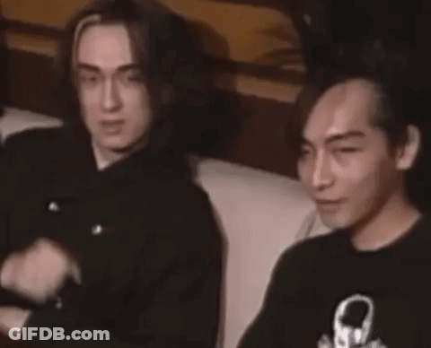 Two Men On Couch One Pointing At Camera GIF