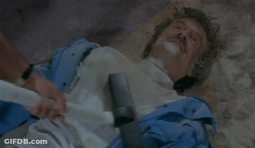 Two Men On Couch Talking, One Smoking Cigarette GIF