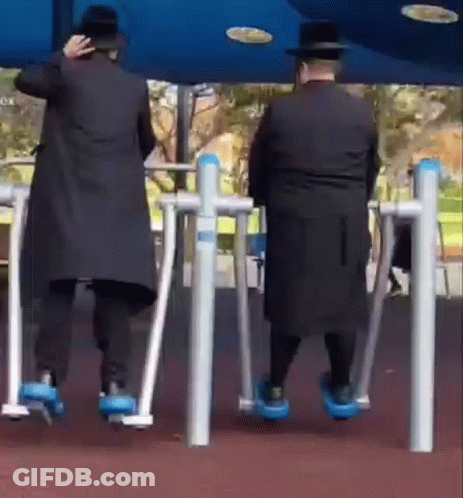 Two Men On Exercise Machines In Park GIF