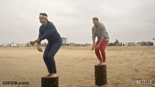 Two Men On Logs At Beach With Netflix GIF
