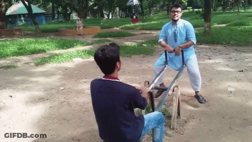 Two Men On Seesaw, One In Blue Shirt GIF