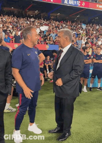 Two Men On Soccer Field With Al Ahly FC Banner GIF