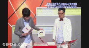 Two Men On Stage One Holding Paper With Chinese Writing GIF
