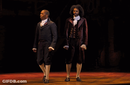 Two Men On Stage One In Suit GIF