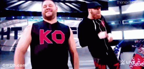 Two Men On Stage One Wearing Ko Shirt GIF