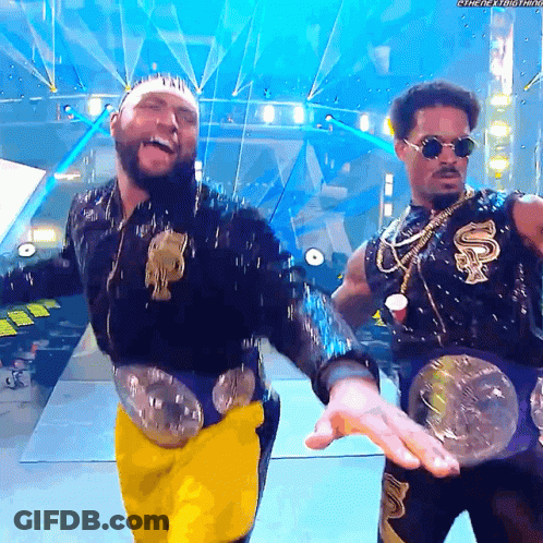 Two Men On Stage, One With Smackdown Belt GIF