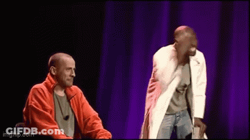 Two Men On Stage With Purple Curtain GIF