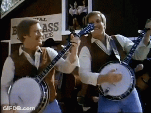 Two Men Playing Banjo And Guitar In Front Of Brass Sign GIF