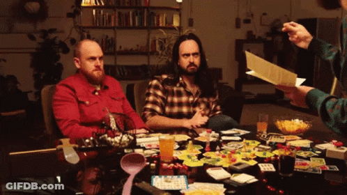 Two Men Playing Board Game While Man Holds Paper GIF