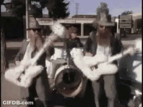 Two Men Playing Guitars And Drums In Band GIF