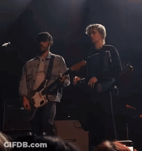 Two Men Playing Guitars On A Stage With A Hiwatt Amplifier In The Background GIF