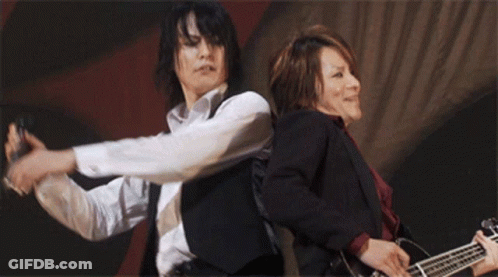 Two Men Playing Guitars White Shirt And Black Vest GIF
