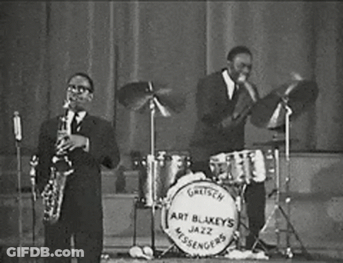 Two Men Playing Saxophone And Drums In Jazz Band GIF