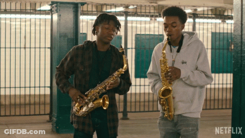 Two Men Playing Saxophones In A Netflix Video GIF
