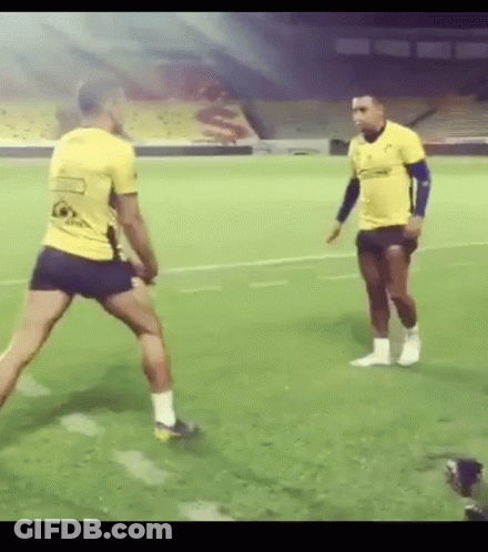 Two Men Playing Soccer In Front Of Stadium GIF