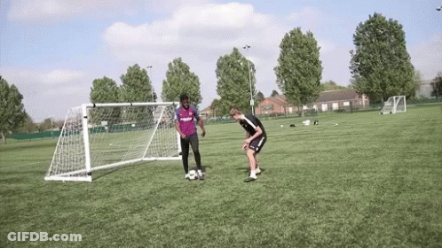 Two Men Playing Soccer One In Purple Shirt GIF