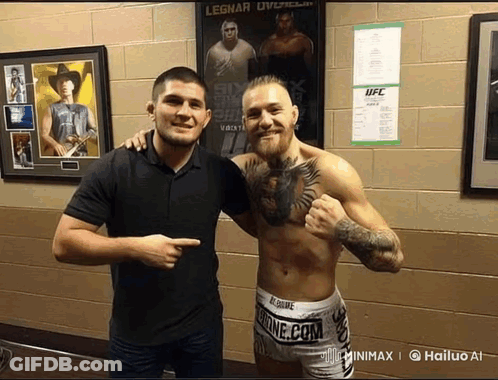 Two Men Posing In Front Of UFC Poster GIF