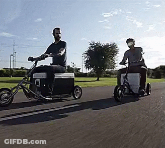 Two Men Riding Motorcycles With Coolers Attached GIF