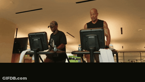 Two Men Running On Treadmills GIF