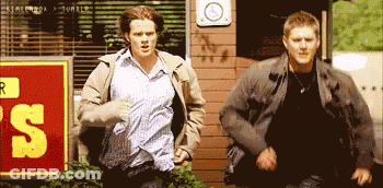 Two Men Running Past Sign 'S GIF