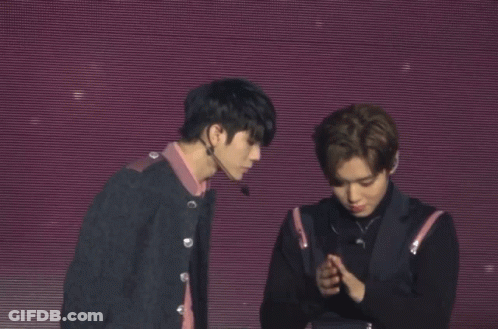Two Men Shake Hands On A Stage With A Purple Background GIF