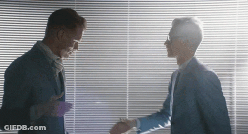 Two Men Shaking Hands In Front Of A Window GIF