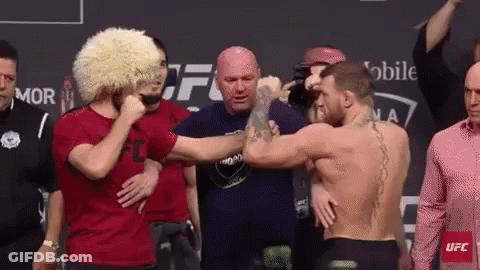 Two Men Shaking Hands In Front Of Crowd GIF