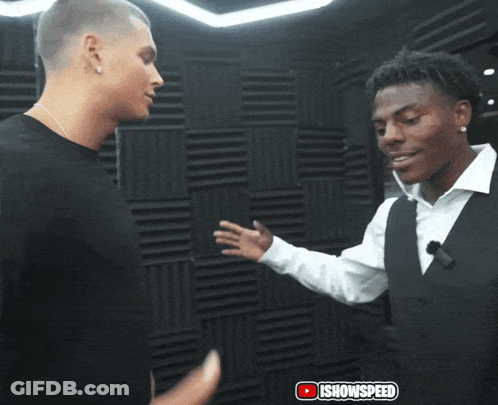 Two Men Shaking Hands In Front Of IShowspeed Wall GIF