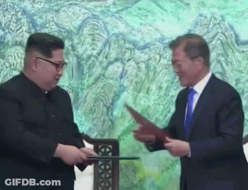 Two Men Shaking Hands In Front Of Painting GIF