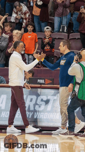 Two Men Shaking Hands In Front Of Poss Sign GIF