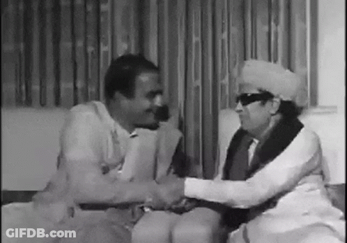 Two Men Shaking Hands On Couch GIF