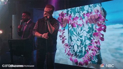 Two Men Singing In Front Of New Amsterdam Screen GIF